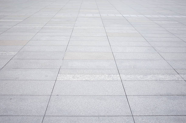Grey brick stone street road. Light sidewalk, pavement texture. Granite outdoor tiled floor.