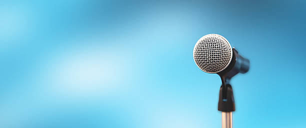 istock Microphone Public speaking backgrounds, Close-up the microphone on stand for speaker speech presentation stage performance with blur and bokeh light background. 2207105440