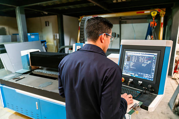 istock Engineer programing a laser cutting machine at a metal factory 2207107038