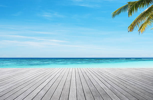 istock Empty wooden platform beside tropical turquoise sea shore 2207112313