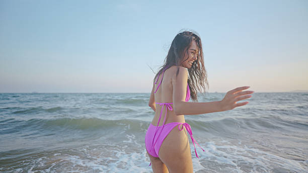 Woman walking in bikini at beach on holiday.