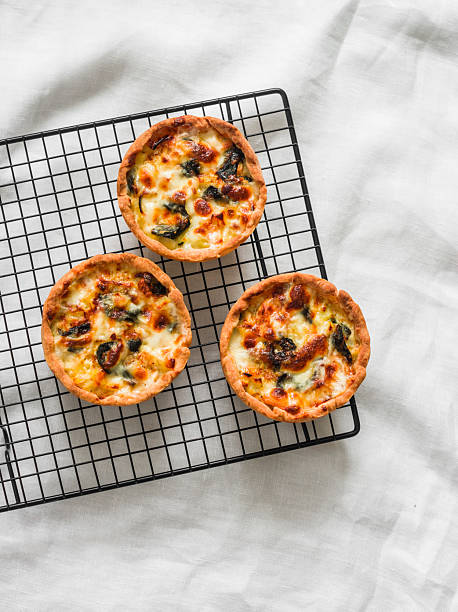 istock Mini pies with chicken, potatoes, spinach and leeks on a baking rack on a light background, top view 2207117056