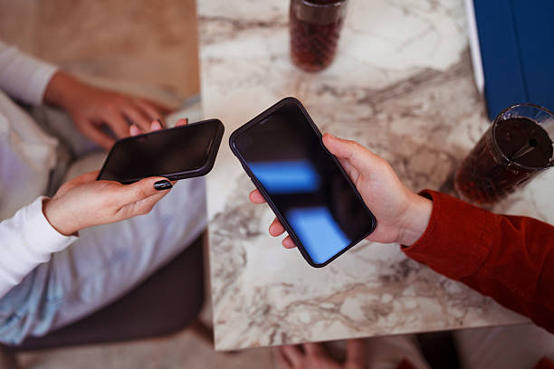 istock Close-Up of Two Smartphones Held Side by Side with Blank Screens 2207118376