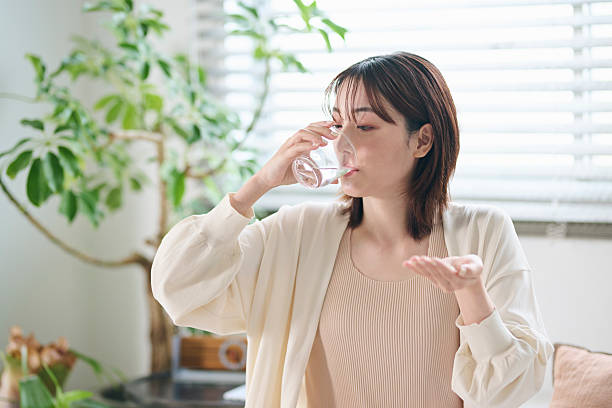 istock A 20-something woman taking a supplement in bed 2207118592