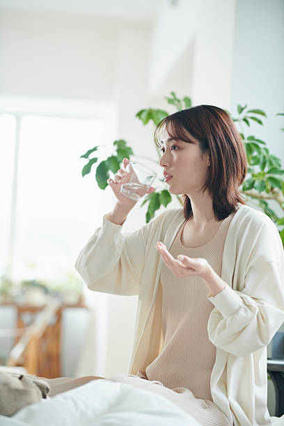istock A 20-something woman taking a supplement in bed 2207118662