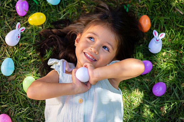 Little girl with her Easter eggs in her garden.