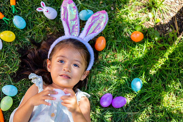 Little girl with her Easter eggs in her garden.