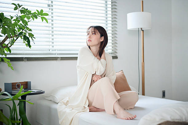 istock A woman in her 20s sitting on a bed 2207119043