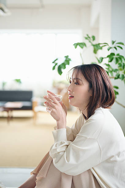 A 20-something woman drinking water in bed