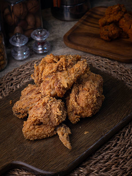 istock Crispy Fried chicken on a wooden plate Set on dark dinning table. 2207120237