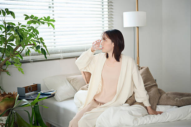 istock A 20-something woman drinking water in bed 2207120702