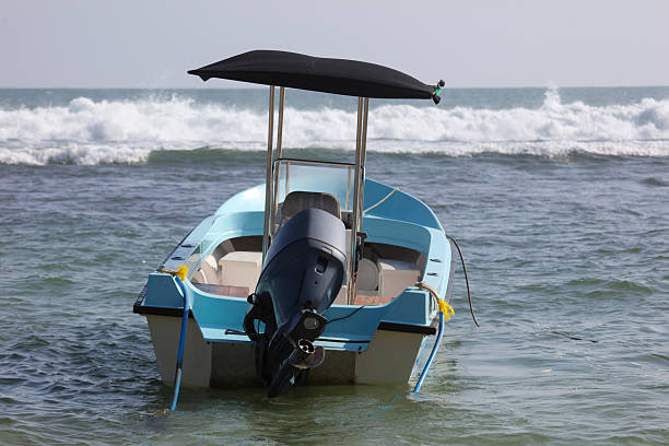 istock A small blue boat with a black canopy is sitting in the water 2207122953