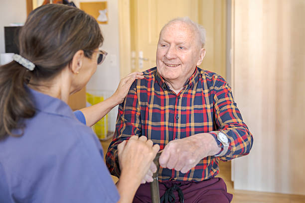 istock Nursing Home - Caregiver with Senior Man 2207124909