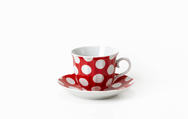 istock Red cup and saucer with white polka dots on a white background, isolated 2207127670
