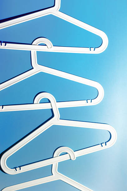 istock White Plastic hangers as minimal pattern on blue gradient background, Clothes rack for organizing clothes in closets or retail stores for hanging of garments, top view, fashion, organization content 2207131202