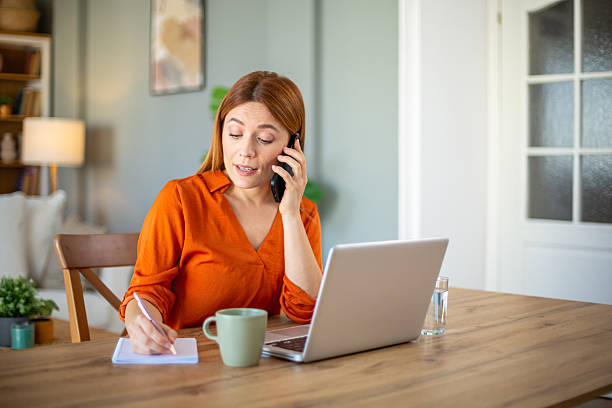 istock Businesswoman taking notes while talking on the phone 2207131294