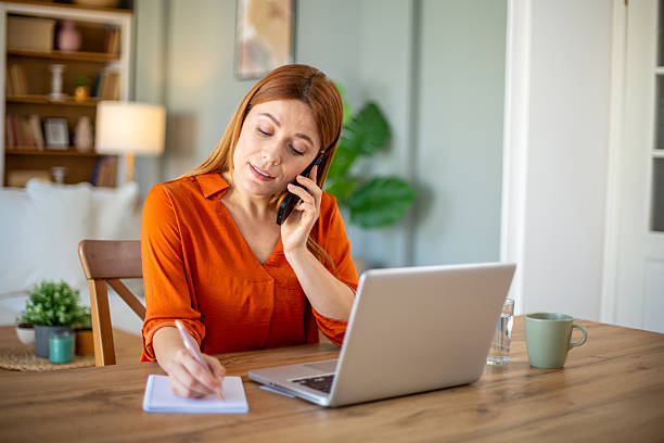 istock Businesswoman taking notes while talking on the phone 2207131402
