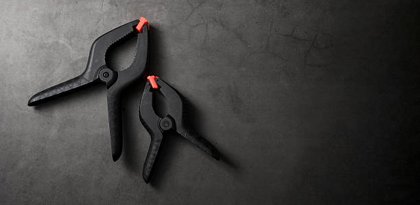 istock Orange black plastic clamp on dark grey stone background 2207133274