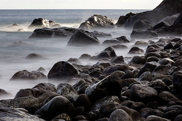 istock long-exposure view of wave breaking on the pebble beach 2207136732