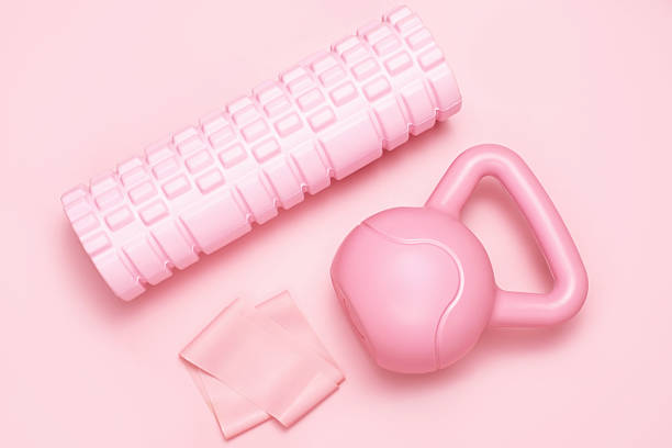 istock Kettlebell and foam roller on a pink background top view close-up. 2207137901