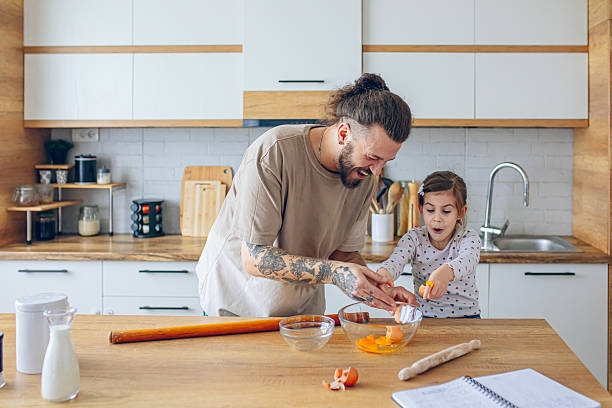istock Daughter helping her father in kitchen 2207139904