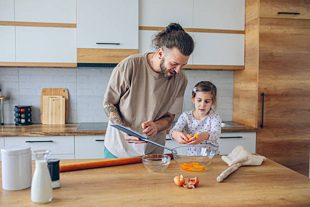 istock Daughter helping her father in kitchen 2207139987