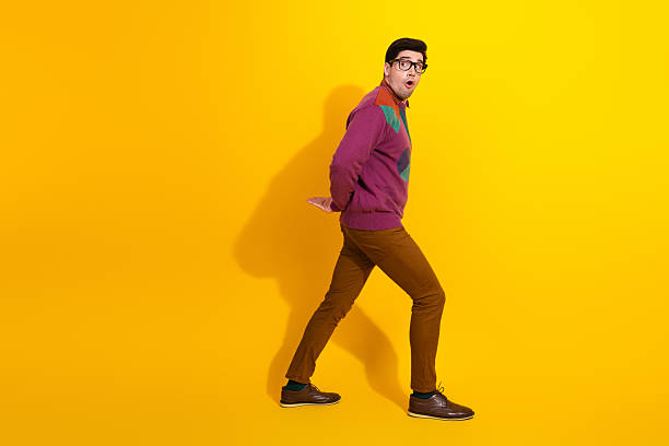 istock Stylish young man wearing glasses making expressive gestures against bright yellow background 2207140128