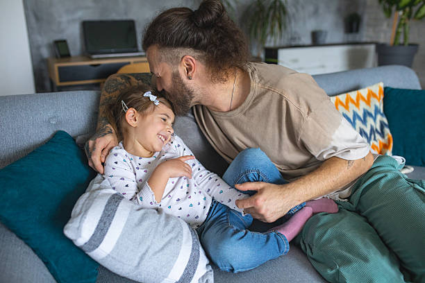 istock Father and daughter playing in living room on sofa 2207140260