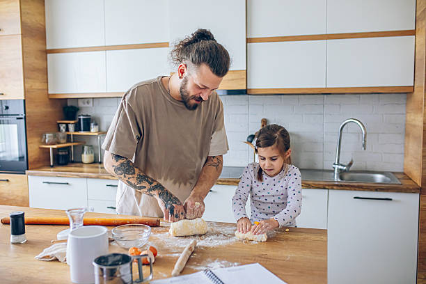 istock Father teaching his daughter how to bake cookies 2207141155