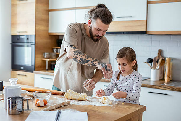 istock Father teaching his daughter how to bake cookies 2207141201