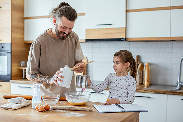 istock Father teaching his daughter how to bake cookies 2207141223