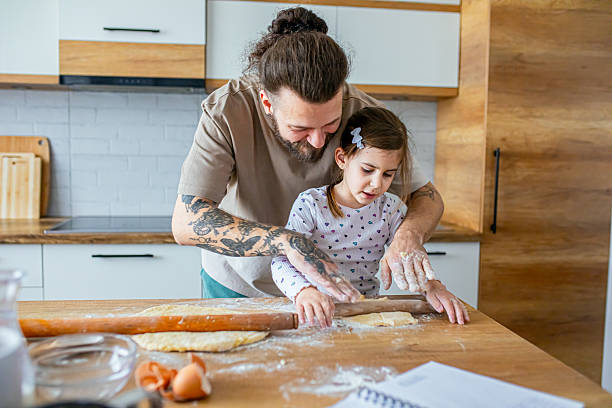 istock Father teaching his daughter how to bake cookies 2207141270