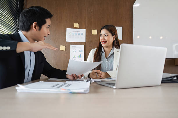 istock Engaging Discussion and Productive Conversations. Two colleagues share insights and strategies while discussing essential documents at work. 2207141764