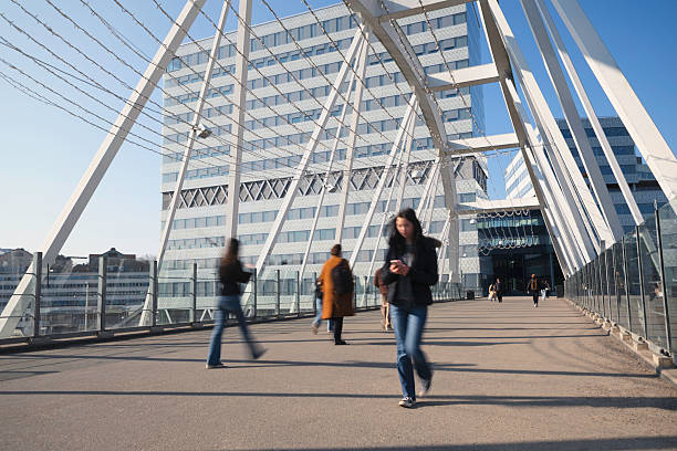 A teenage student using a phone while crossing a bridge in the modern Arenastaden district of Solna outside Stockholm, Sweden.