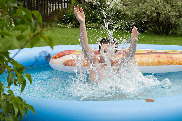 istock Teenager boy playing in pool at back yard. Summer fun vacation 2207144492