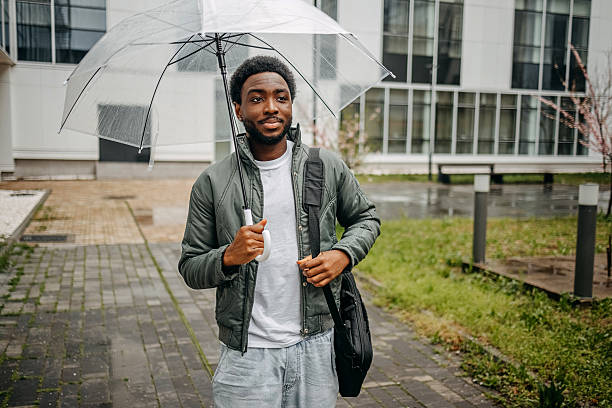 istock Man going to work walking outside on rainy day carrying laptop bag on shoulder 2207145445