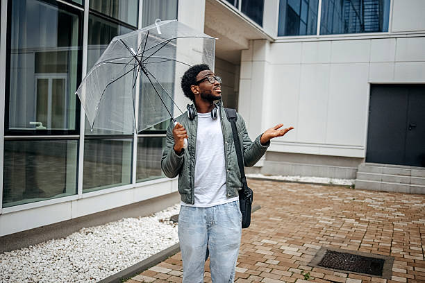 istock Man going to work walking outside on rainy day carrying laptop bag 2207145454