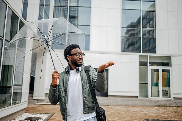 istock Man going to work walking outside on rainy day carrying laptop bag 2207145461