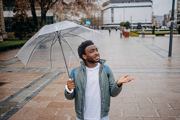 istock Man going to work walking outside on rainy day carrying laptop bag 2207145510