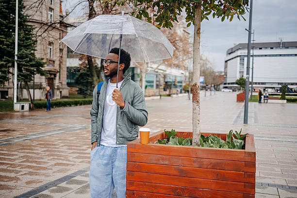 istock Man going to work walking outside on rainy day and having coffee to go 2207145621