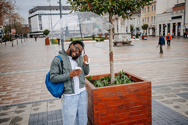 istock Man going to work walking outside on rainy day while talking on mobile phone 2207145628