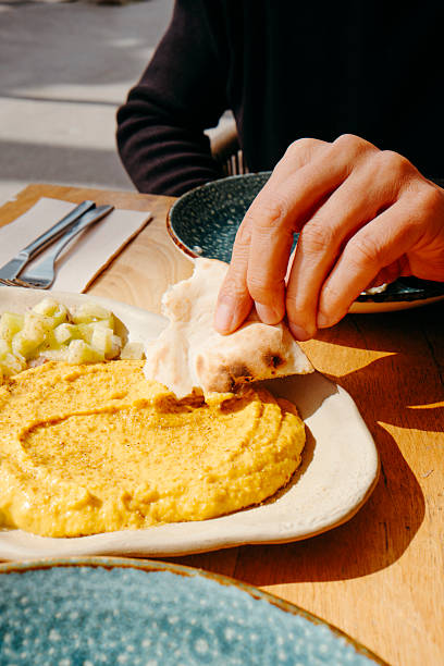 istock man dips a piece of naan bread on hummus 2207147845