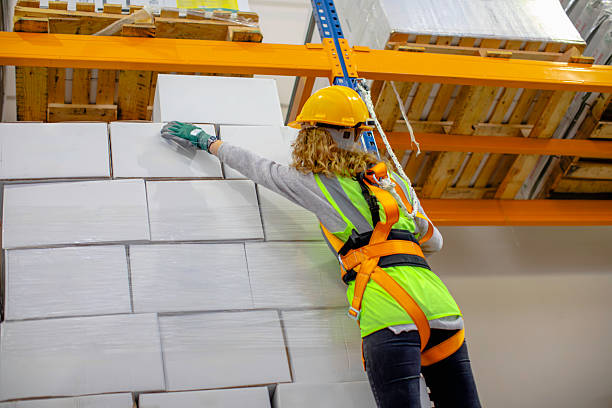 istock Warehouse worker wearing safety harness hanging on a climbing rope during high shelf operation. 2207151237
