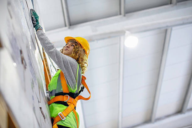 istock Warehouse worker hanging on a climbing rope while organizing boxes on high shelf. 2207151252