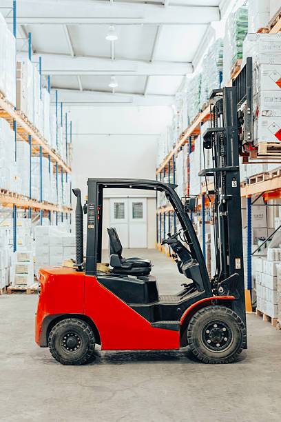 istock Forklift vehicle parked inside organized warehouse aisle filled with stacked boxes and goods. 2207151277