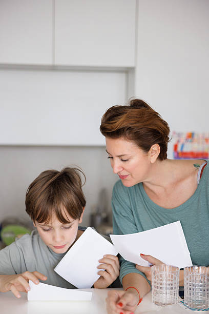 istock Preadolescent boy looking at photos with his mother at the table 2207152297