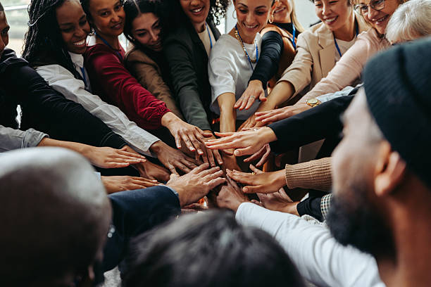 istock Diverse coworkers putting hands in for a unified team huddle at work 2207152343