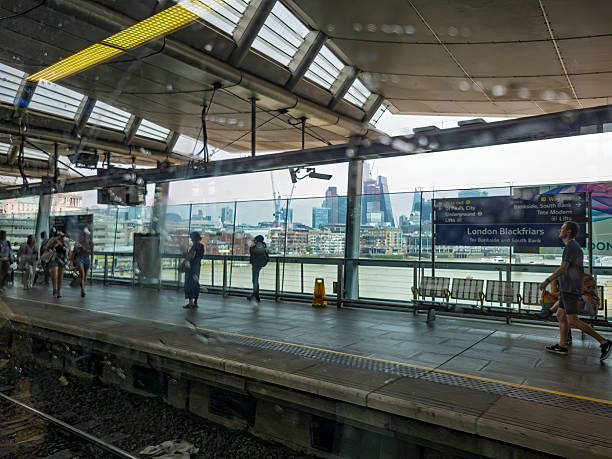 Blackfriars Station, Blackfriars bridge, London, UK, June 2022. Blackfriars station on the London Underground with passengers on the platform and the City of London skyscrapers in the background.