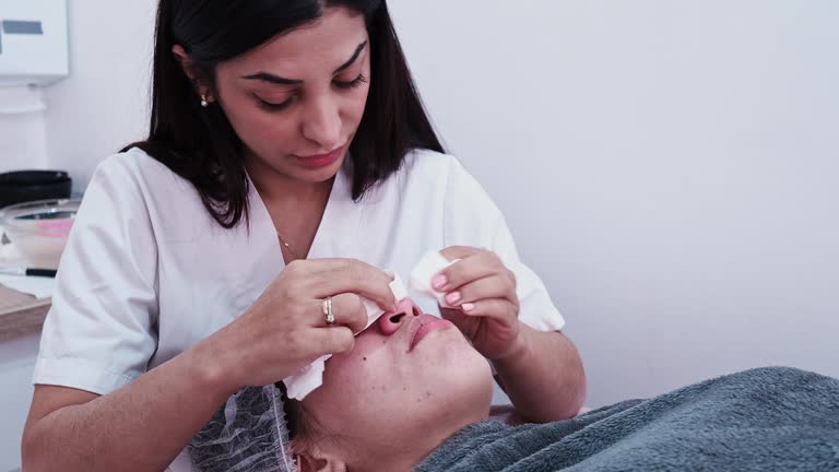 An aesthetician extracts pores during a deep facial cleansing in a beauty clinic