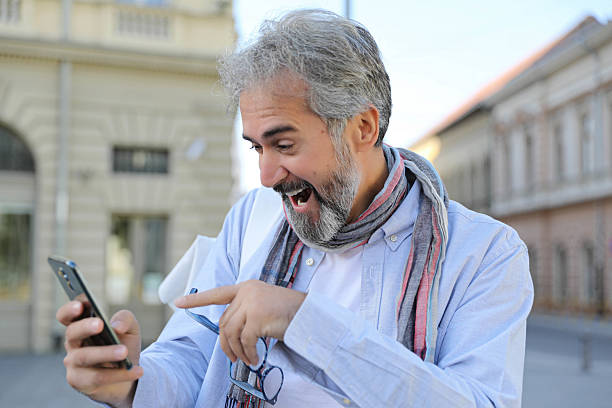 Charming Middle-Aged Bearded Male Tourist Exploring the Old Town with Smartphone Assistance
